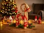 Julenegleget figur af halm formet som en ged, pyntet med rødt bånd. Står på et træbord med gran og julepynt. Perfekt til juledekoration. - Billedet er skabt med AI