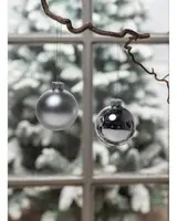 Set med två julgranskulor, en matt silver och en blank krom, båda runda med silverfäste och upphängning. Elegant, minimalistisk design för festlig dekoration.