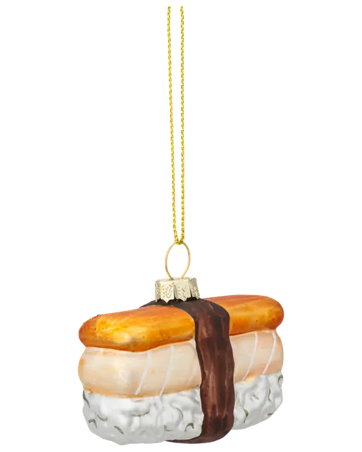 Glasornament formet som en musubi med hvid ris, et stykke kød og en brun stribe som tang, samt en guldfarvet ophængssnor.
