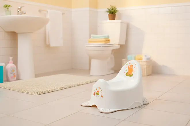 Vit plastpotta med djurmotiv, ergonomiskt ryggstöd och halkfri botten. Lämplig för småbarn, lätt och enkel att rengöra. Visas i modernt badrum.