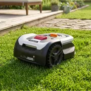 Robotplæneklipper med sort og hvidt kabinet, store terrængående hjul og kontrolknapper på toppen. Til automatisk græsslåning i haver. Kompakt og moderne design.