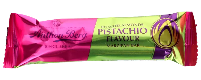 Anthon Berg marcipanbar med ristede mandler og pistaciesmag, indpakket i skinnende pink og grøn emballage med produktnavn og pistacieillustration på forsiden.