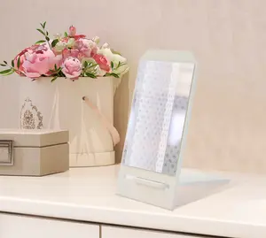 Rektangulär bordsspegel med vit ram och vikbart stativ. Modern och lätt design, perfekt för smink eller grooming på bord eller skrivbord.