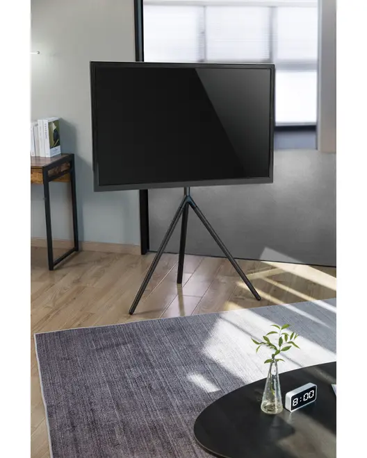 Moderne fladskærms-tv med slank sort ramme, monteret på et minimalistisk sort trefodsstativ. Velegnet til moderne indretning og giver en stilfuld, pladsbesparende løsning.
