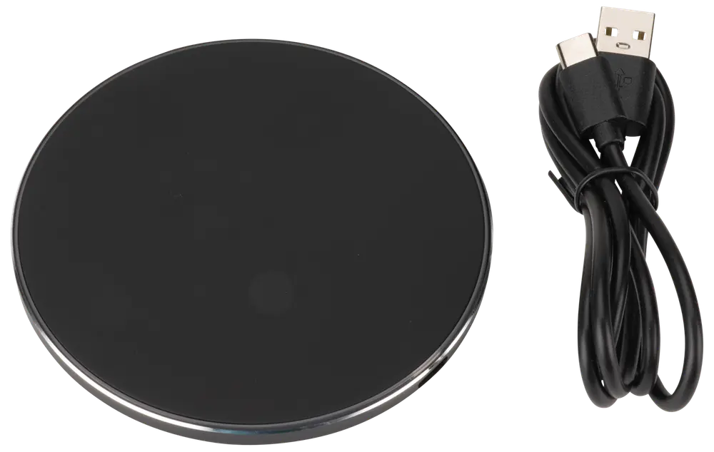 Rund svart trådlös laddningsplatta med slät yta, silverkant och medföljande USB-kabel för ström. Passar för laddning av kompatibla smartphones och enheter utan sladd.