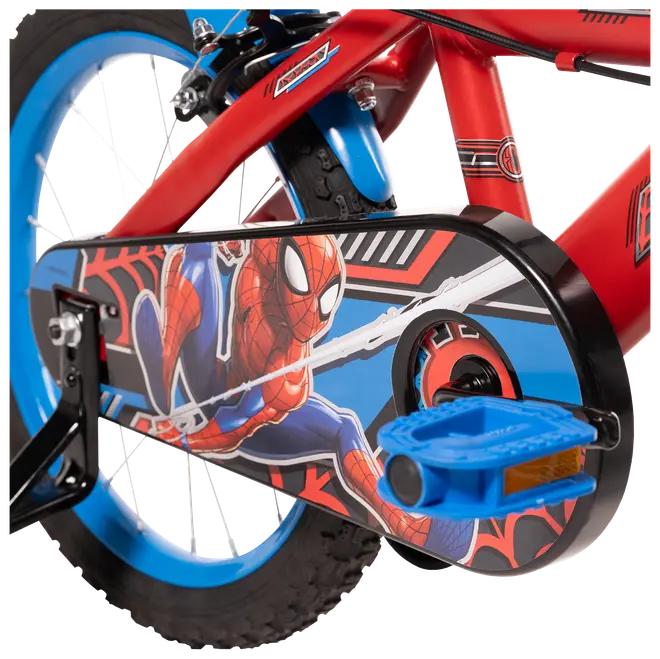 Barncykel med röd ram, blå hjul och kedjeskydd med färggrafik av Spider-Man. Utrustad med blå pedaler och stödhjul för extra stabilitet.