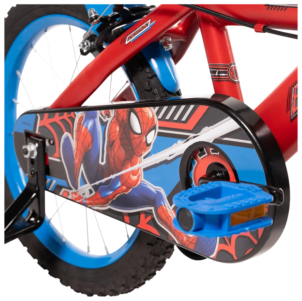 Barncykel med röd ram, blå hjul och kedjeskydd med färggrafik av Spider-Man. Utrustad med blå pedaler och stödhjul för extra stabilitet.