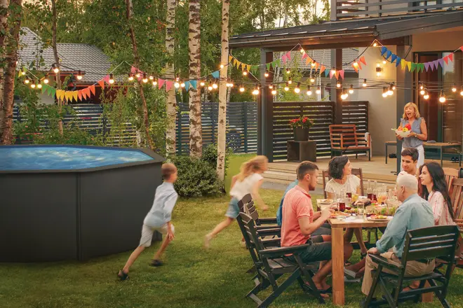 Rund fritstående pool med blåt vand, robust mørk yderside, velegnet til udendørs brug. Perfekt til familiesammenkomster, nem at opstille i haven, plads til flere personer.