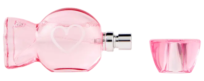 Lyserød parfume flaske formet som et indpakket slik, med hjerte-design foran. Låget er også lyserødt og ligger ved siden af flasken. Elegant og legende design.