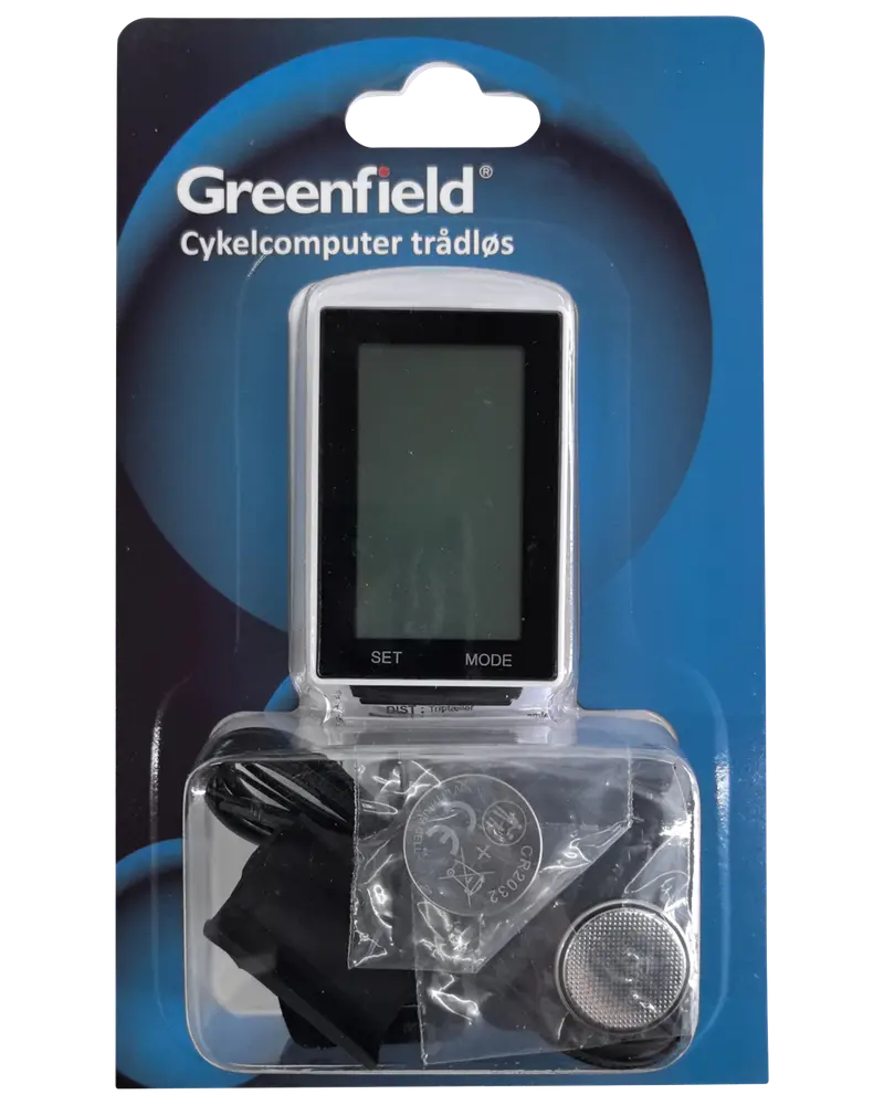 Trådlös cykeldator från Greenfield i förpackning, med digital display, monteringsdelar och batteri. Displayen har 'SET' och 'MODE' knappar. För cykeldataregistrering.