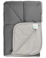 Grå og lysegrå dyne med quiltet syning, blød tekstur og hjørnemærke med materiale- og plejeinstruktioner. Velegnet til sengetøj, giver varme og komfort.