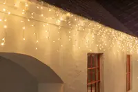 Varmvita LED-ljusslingor med istappsdesign, passar för utomhus- eller inomhusdekoration. Flera hängande trådar, energisnåla lampor och strömanslutning.