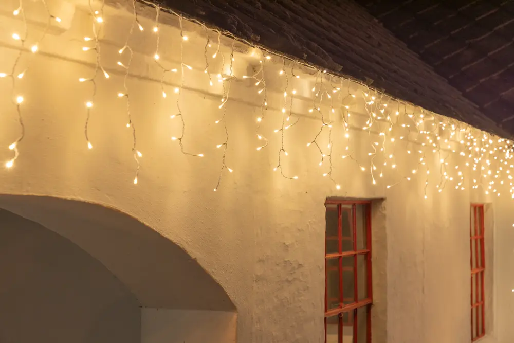 Varmvita LED-ljusslingor med istappsdesign, passar för utomhus- eller inomhusdekoration. Flera hängande trådar, energisnåla lampor och strömanslutning.