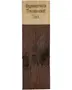 Rektangulær træprøve mærket 'Sagasupreme Transparent Teak'. Nederste del er dækket af en mørkebrun, transparent teakfinish, hvor træets årer og knaster er synlige.