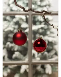 Set med två röda julgranskulor, en matt och en blank, båda med guldfärgad topp och hängande snöre. Klassisk rund form, perfekt för juldekoration.