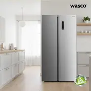 Moderne side-by-side køleskab i rustfrit stål, lodrette håndtag, digitalt display på højre dør, rummeligt interiør, energieffektivt. Inkluderer 3 års garanti-mærkat.