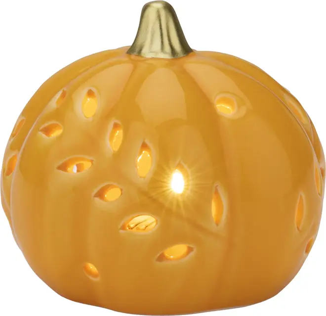 Keramisk fyrfadsstage formet som et græskar med blank orange overflade, gylden stilk og flere bladformede udskæringer, hvor lyset skinner igennem. Dekorativ efterårs- eller Halloweenpynt.