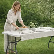 Kvinde dækker bord til gæster i haven på foldebord