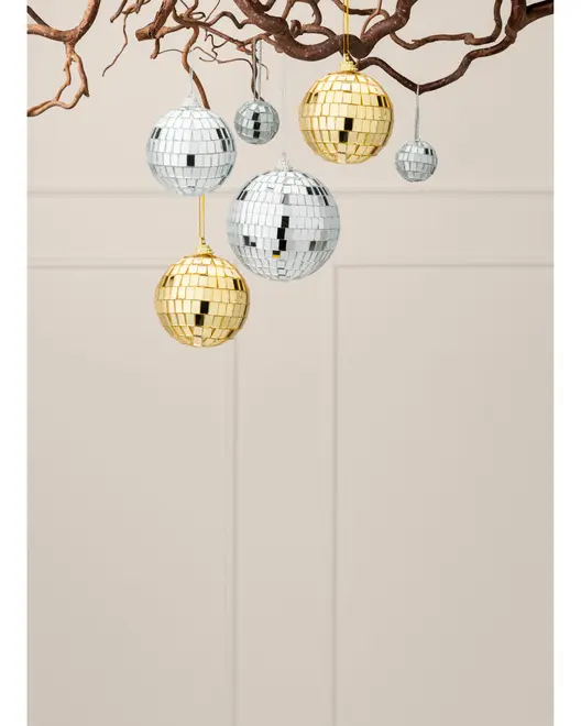 Set med spegelklädda discokuleornament i silver och guld, upphängda i grenar med snören och reflekterande mosaikplattor.