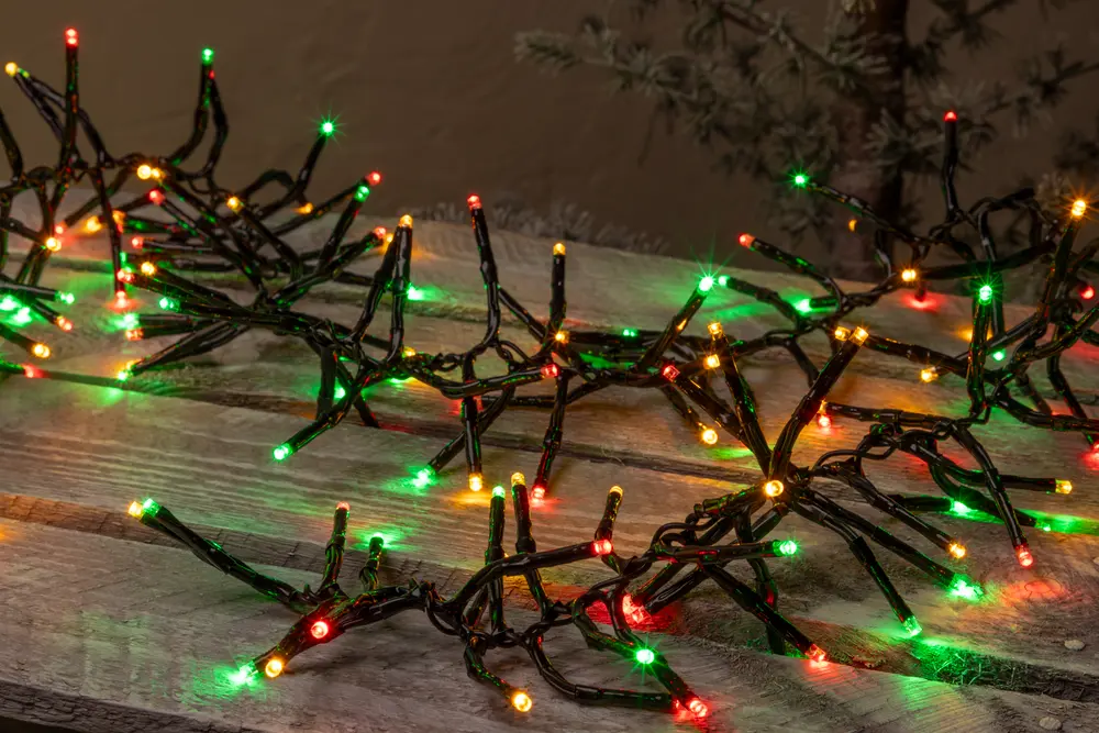 Ljusslinga med röda, gröna och gula LED-lampor på svart sladd, arrangerad i förgrenat mönster, passar för inomhus- eller utomhusdekoration vid jul.