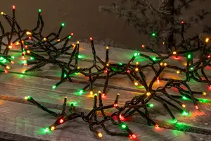 Ljusslinga med röda, gröna och gula LED-lampor på svart sladd, arrangerad i förgrenat mönster, passar för inomhus- eller utomhusdekoration vid jul.
