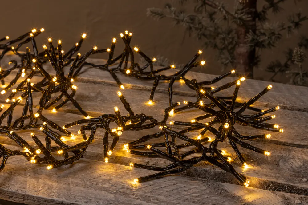 Svart grenformad LED-ljusslinga med varmgula lampor, perfekt för dekoration. Flexibla grenar möjliggör kreativ placering på bord, hyllor eller vid festliga arrangemang.