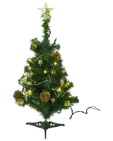 Liten konstgjord julgran med guldfärgade dekorationer, kottar, gula LED-lampor och guldfärgad stjärna. Levereras med svart fot, passar bord eller små utrymmen.