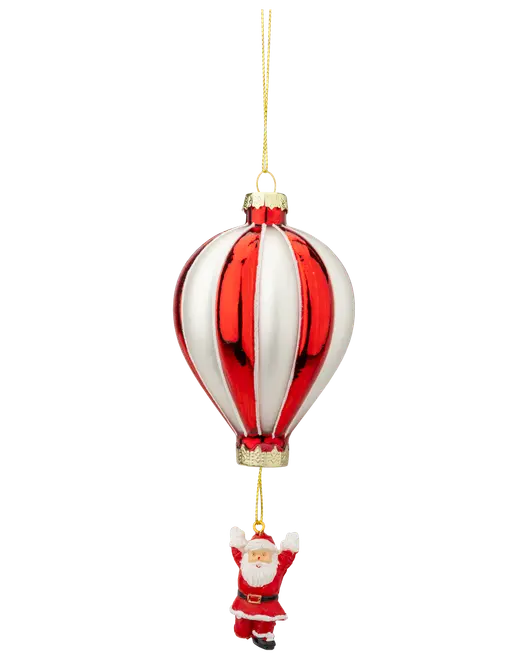 Julepynt i glas formet som en rød og hvid luftballon med en lille julemand hængende nedenunder, fastgjort med en guldsnor til ophængning.