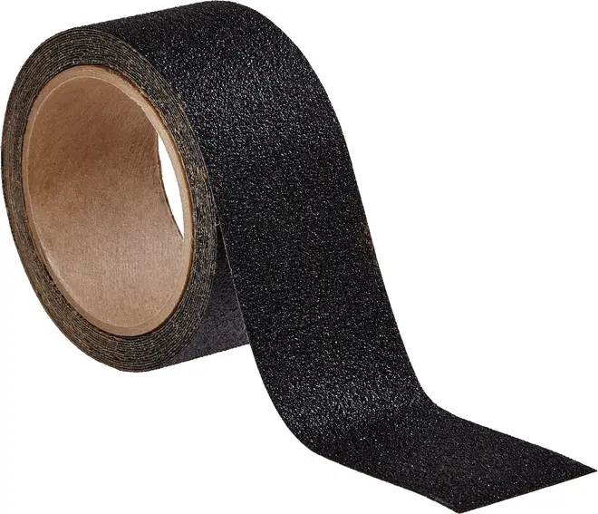 Rulle med sort skridsikkert tape med ru, tekstureret overflade og papkerne, designet til ekstra greb på trapper, ramper eller glatte overflader.