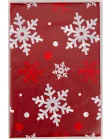 Rött presentpapper med stora vita och röda snöflingor samt prickar. Festlig design för jul- eller vinterklappar. Slät, blank yta ger ett elegant intryck.