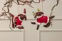Sæt med to filt-julehundepynt, én klædt som julemand og én som rensdyr med lyskæde, begge med røde og hvide dragter, hængende fra grene.