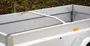 Sølvfarvet aluminiums-anhænger med høje sidepaneler, hjørnebeslag og en buet støttearm.
