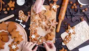 Blandade pepparkakor i form av stjärnor, snöflingor och gubbar, några dekorerade med vit glasyr, upplagda på träbrädor med kakformar och kavel.